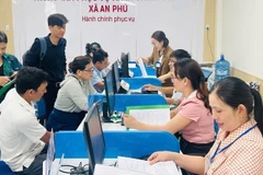 Cán bộ, viên chức xã An Phú hướng dẫn thủ tục hành chính cho người dân vùng biển Quảng Ngãi. (Ảnh ĐÔNG HUYỀN)