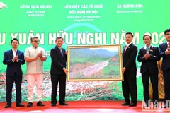 Đại diện lãnh đạo xã Hương Sơn tặng Đoàn đại biểu Du xuân bức tranh về suối Yến trong quần thể di tích Hương Sơn.