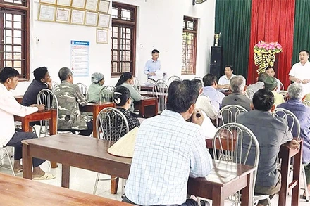 Cán bộ xã đối thoại với người dân có đất được thu hồi để triển khai dự án điện.