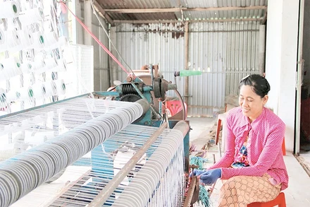 Bà Nguyễn Thị Minh Trang, chủ cơ sở dệt chiếu ấp Ðức Mỹ, xã Nhị Long, tỉnh Vĩnh Long dệt chiếu bằng máy bán tự động.