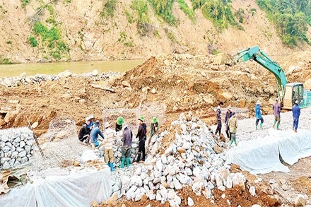 Công nhân Công ty cổ phần đường bộ 2 tập trung khắc phục Quốc lộ 12, đoạn Km 261+900 (Pá Vạt-Mường Luân) bị lũ cuốn mất toàn bộ mặt đường.