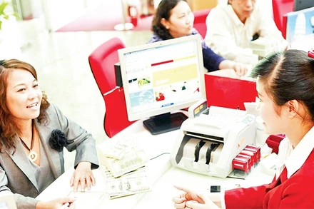 Giao dịch vay vốn tại một ngân hàng thương mại ở Thành phố Hồ Chí Minh. (Ảnh THẾ ANH)