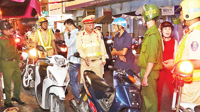 Lực lượng cảnh sát tuyên truyền, nhắc nhở người dân không đậu, đỗ xe dưới lòng đường.