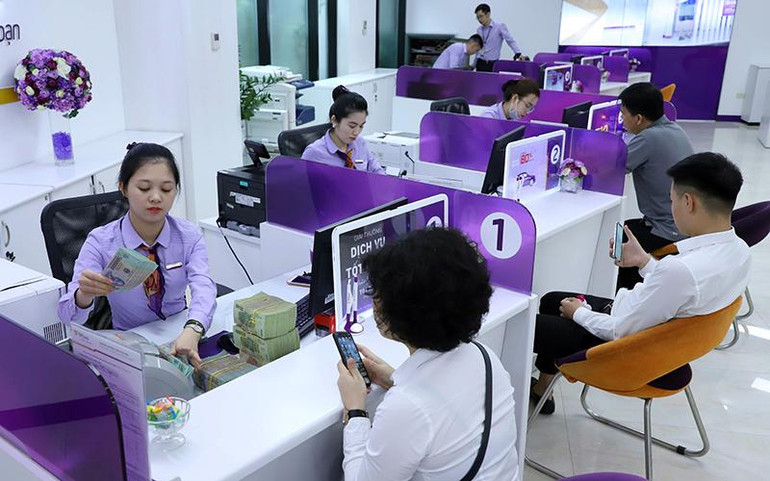 Khách hàng làm thủ tục giao dịch tại Ngân hàng TP Bank. (Ảnh VIẾT CHUNG)