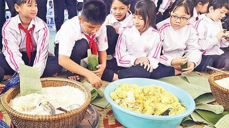 Các em học sinh được trải nghiệm gói bánh chưng.