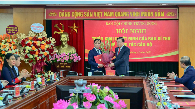 Đồng chí Phan Đình Trạc, Ủy viên Bộ Chính trị, Bí thư Trung ương Đảng, Trưởng Ban Nội chính Trung ương trao Quyết định và tặng hoa chúc mừng đồng chí Nguyễn Xuân Trường. (Ảnh: BẢO LONG)