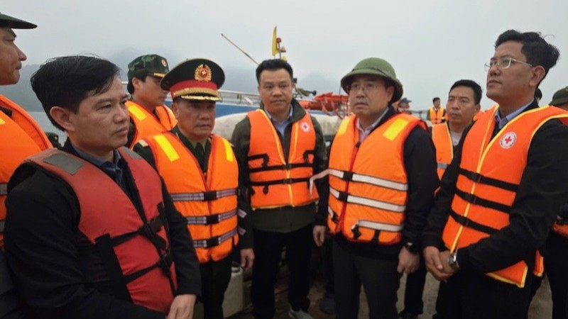 Chủ tịch Ủy ban nhân dân tỉnh Lào Cai Nguyễn Tuấn Anh (người đội mũ, thứ ba từ phải sang) trực tiếp có mặt tại hiện trường, chỉ đạo công tác cứu hộ các nạn nhân bị chìm tàu trên hồ Thác Bà tối 21/2.