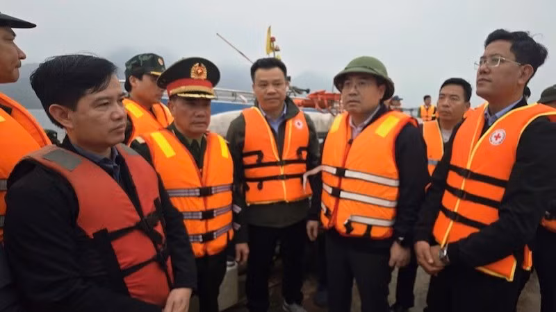 Chủ tịch Ủy ban nhân dân tỉnh Lào Cai Nguyễn Tuấn Anh (người đội mũ, thứ ba từ phải sang) trực tiếp có mặt tại hiện trường, chỉ đạo công tác cứu hộ các nạn nhân bị chìm tàu trên hồ Thác Bà tối 21/2.