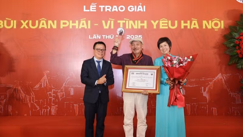 Đồng chí Lê Quốc Minh, Ủy viên Trung ương Đảng, Tổng Biên tập Báo Nhân Dân, Phó Trưởng ban Tuyên giáo và Dân vận Trung ương, Chủ tịch Hội Nhà báo Việt Nam cùng lãnh đạo Thông tấn xã Việt Nam trao Giải thưởng Lớn - Vì tình yêu Hà Nội được trao cho nhạc sĩ Trần Tiến.