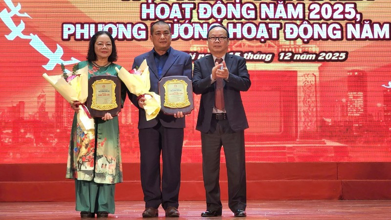 Nhà văn Nguyễn Xuân Tuấn (đứng giữa) và đại diện ủy quyền nhà văn Bành Thanh Bần (ngoài cùng bên trái) được trao giải thưởng Cống hiến sau nhiều đóng góp cho sự phát triển của văn học Thủ đô.