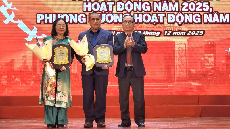 Nhà văn Nguyễn Xuân Tuấn (đứng giữa) và đại diện ủy quyền nhà văn Bành Thanh Bần (ngoài cùng bên trái) được trao giải thưởng Cống hiến sau nhiều đóng góp cho sự phát triển của văn học Thủ đô.