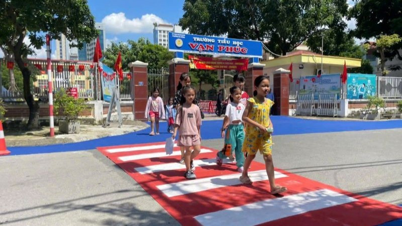 Học sinh Trường tiểu học Vạn Phúc (Hà Nội) tự tin đi trên đoạn đường dành riêng cho người đi bộ khu vực trước cổng trường.