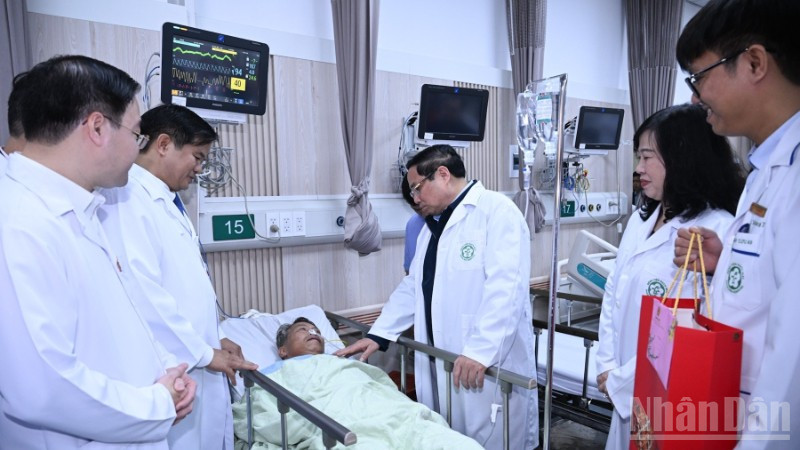 Thủ tướng Phạm Minh Chính thăm, tặng quà chúc Tết một bệnh nhân đang điều trị tại Trung tâm cấp cứu A9, Bệnh viện Bạch Mai. (Ảnh: Trần Hải)