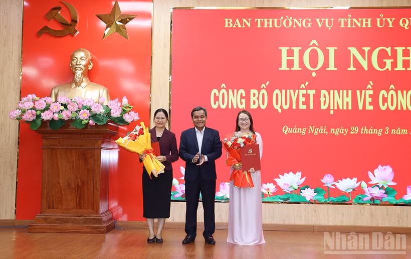 Đồng chí Hồ Văn Niên, Ủy viên Trung ương Đảng, Bí thư Tỉnh ủy Quảng Ngãi trao quyết định và tặng hoa chúc mừng đồng chí Hà Thị Anh Thư và Huỳnh Thị Ánh Sương.
