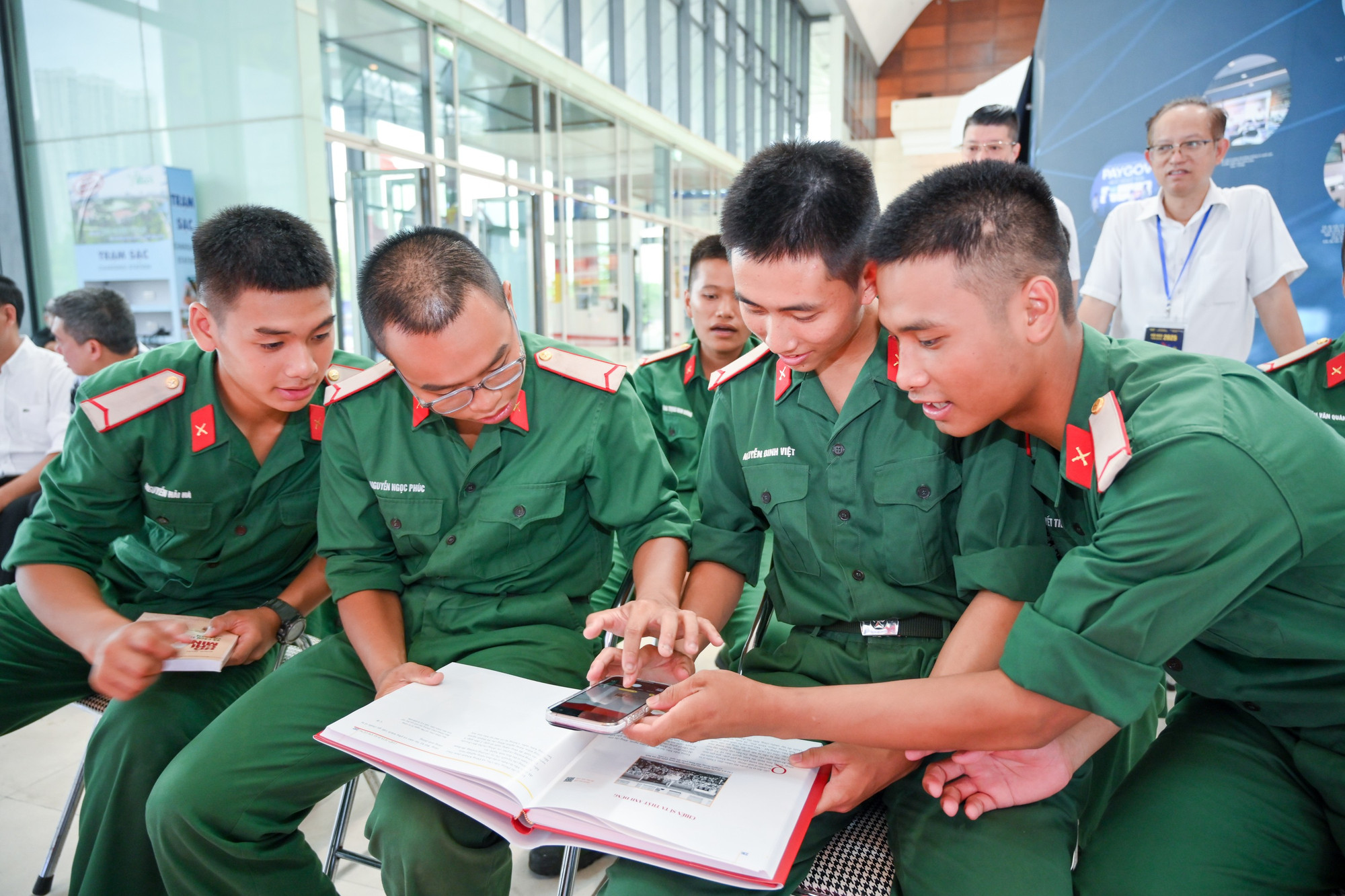 Các chiến sĩ dùng điện thoại để quét mã QR trên cuốn sách. hoi-bao-3533.jpg