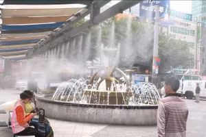 Người dân làm mát dưới đài phun nước khi nắng nóng gay gắt bao trùm thành phố Busan, Hàn Quốc ngày 29/5/2026. (Ảnh: YONHAP/TTXVN)