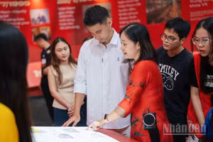 Du khách trải nghiệm sách tương tác tại Triển lãm "95 năm Cờ Đảng soi đường".