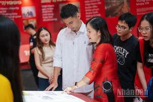 Du khách trải nghiệm sách tương tác tại Triển lãm "95 năm Cờ Đảng soi đường".