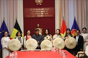 Ông Đỗ Phước Trung, Phó Giám đốc Sở Văn hóa và Thể thao Thành phố Hồ Chí Minh, trao tặng sách cho ông Huỳnh Công Mỹ, Chủ tịch Tổng hội người Việt Nam tại Vương quốc Bỉ. (Ảnh: TTXVN)