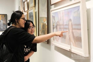 Công chúng thưởng thức tác phẩm "Tính nữ" của Đỗ Trà My. (Ảnh: DUNG NHI)