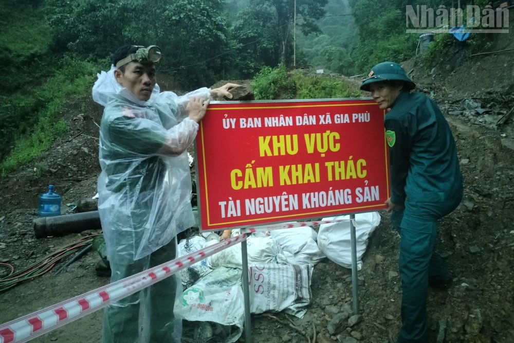 Lực lượng túc trực gia cố lại những tấm biển thông báo do mưa to gây lũ lớn, nguy cơ cuốn trôi tấm biển báo. ndo_tr_19.jpg