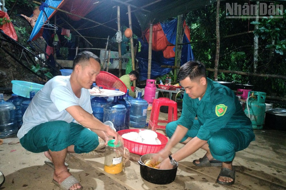 Cán bộ túc trực trên lán nấu ăn tối từ những dụng cụ nấu ăn được tận dụng lại của các đối tượng khai thác vàng trái phép. ndo_tr_4.jpg