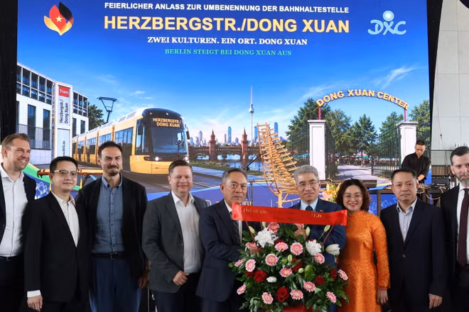 Đại sứ Nguyễn Đắc Thành và Phu nhân tặng hoa chúc mừng ông Nguyễn Văn Hiền, Tổng giám đốc Trung tâm Thương mại Đồng Xuân Berlin. (Ảnh: TTXVVN)