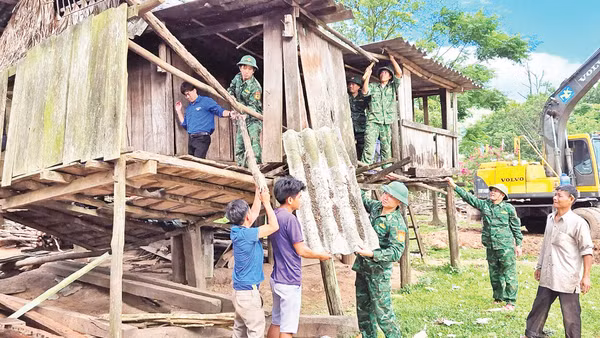 Bộ đội Biên phòng cùng thanh niên tình nguyện và các hộ dân ở xã biên giới Dân Hóa, huyện Minh Hóa tháo dỡ các mái nhà dột nát để làm nhà mới.