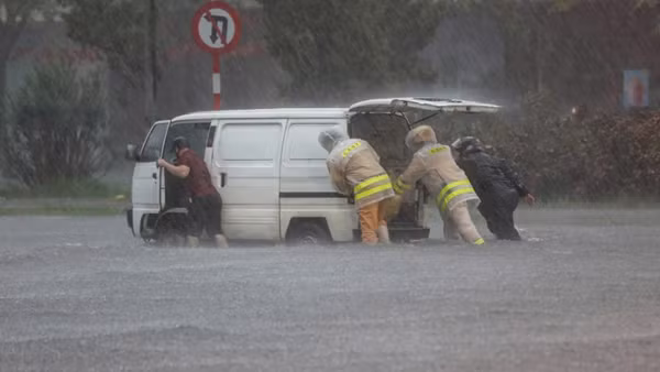 Đường phố ngập sâu, cảnh sát giao thông dầm mưa cùng người dân di chuyển phương tiện đến nơi an toàn.