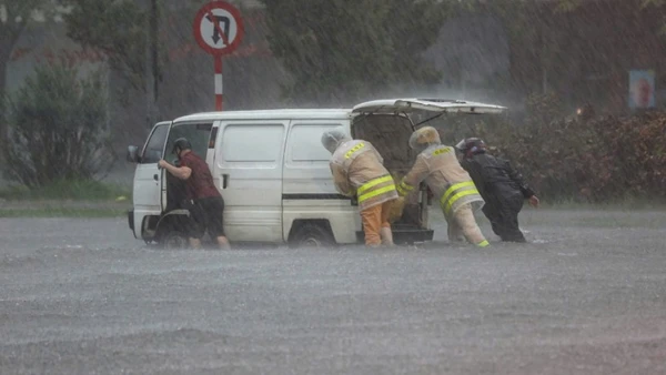Đường phố ngập sâu, cảnh sát giao thông dầm mưa cùng người dân di chuyển phương tiện đến nơi an toàn.