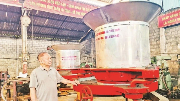 Bác Vũ Hữu Lê bên sản phẩm máy vò chè đa năng.