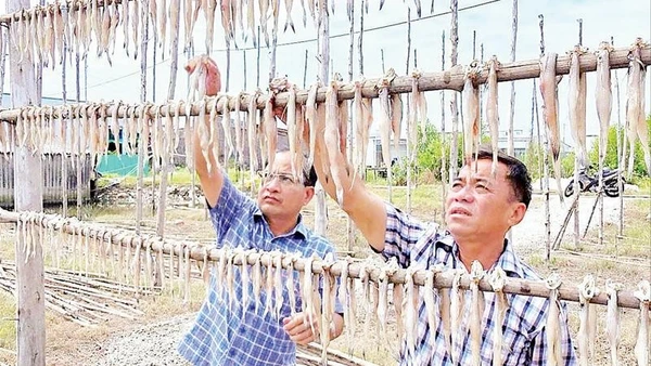 Chủ một cơ sở sản xuất kiểm tra chất lượng sản phẩm.