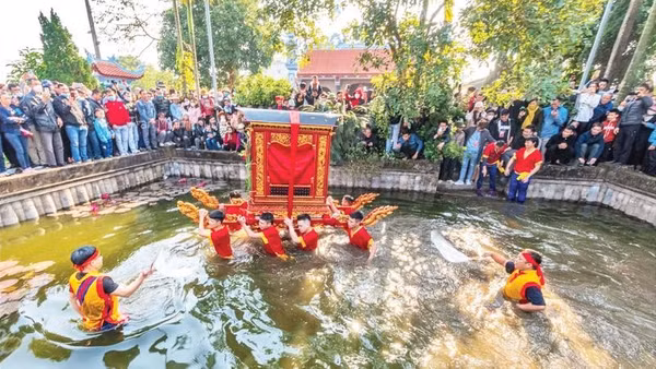 Trai tráng làng Thọ Lộc rước kiệu dưới nước, trước sự cổ vũ của người dân.