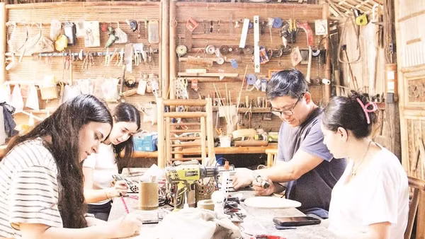 Anh Võ Tấn Tân hướng dẫn khách trải nghiệm làm sản phẩm thủ công mỹ nghệ từ tre.