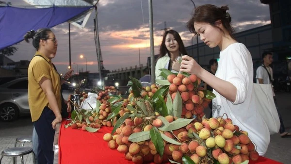 Công nhân khu công nghiệp Nội Hoàng, Bắc Giang trải nghiệm gian hàng vải thiều sau giờ tan ca.