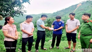 Chính quyền xã Đồng Tiến thăm hỏi, hỗ trợ gia đình có người bị lũ cuốn trôi. (Ảnh: CHÍ CƯỜNG)