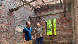Cán bộ xã Yên Phúc, tỉnh Lạng Sơn (áo kẻ) đến thăm gia đình bà Nông Thị Việt (vợ liệt sĩ) đang được hỗ trợ xây mới nhà ở. 