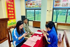 Đoàn viên thanh niên xã Cẩm Bình, tỉnh Hà Tĩnh hướng dẫn người dân làm hồ sơ trực tuyến.