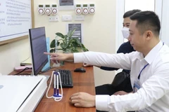 Người dân đang được hướng dẫn thực hiện thủ tục hành chính trên môi trường mạng. (Ảnh minh họa)