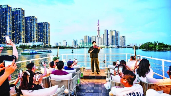 Khách du lịch trong nước và nước ngoài trải nghiệm buýt trên sông Sài Gòn vào ban đêm. (Ảnh: THÀNH ĐẠT)