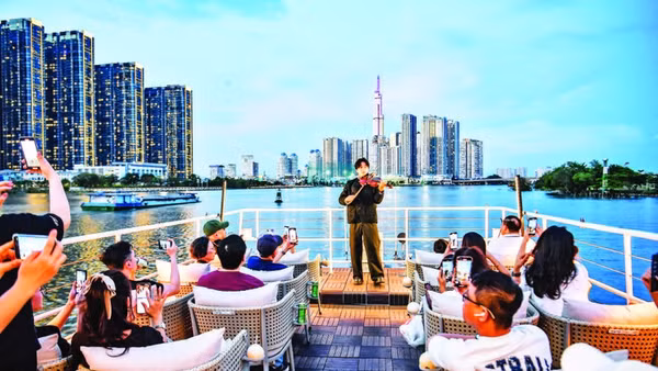 Khách du lịch trong nước và nước ngoài trải nghiệm buýt trên sông Sài Gòn vào ban đêm. (Ảnh: THÀNH ĐẠT)