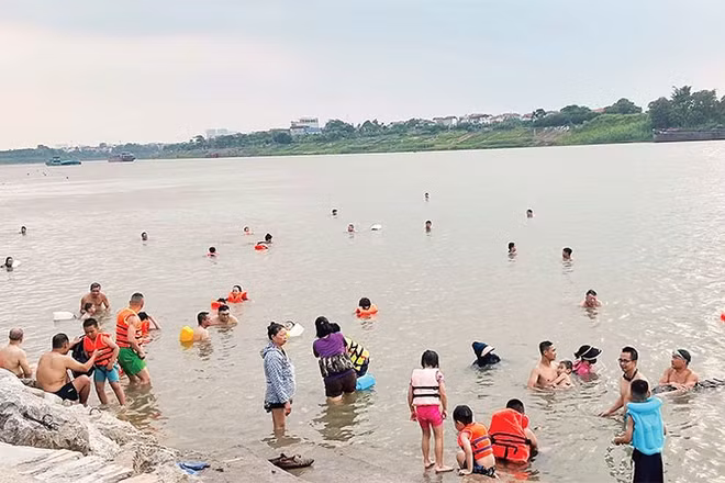 Nhiều gia đình mang cả trẻ nhỏ ra sông bơi lội dù không đủ các điều kiện an toàn.