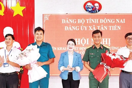Lãnh đạo xã Tân Tiến (tỉnh Đồng Nai) tặng hoa chúc mừng các đồng chí sĩ quan về nhận nhiệm vụ tại Ban Chỉ huy quân sự xã.