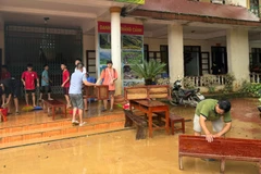 Thầy giáo và các em học sinh trường THCS Yên Biên, phường Hà Giang 2 khẩn trương dọn dẹp cơ sở vật chất sau lũ. (Ảnh: KHÁNH TOÀN)