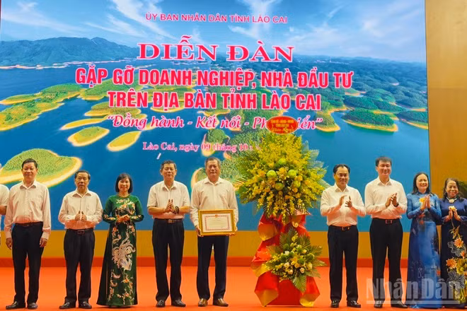 Lãnh đạo tỉnh Lào Cai tặng hoa và Bằng khen đối với Hiệp hội Doanh nghiệp tỉnh. (Ảnh: THANH SƠN)