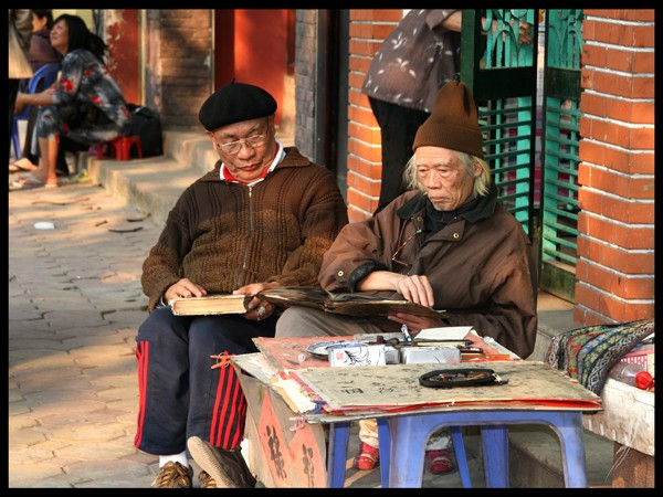 Cuối năm 2010, Hà Nội vẫn còn thở theo nhịp chậm, nơi vỉa hè không chỉ để đi mà còn là nơi hành nghề, trao chuyện, và lắng ký ức. Hai người đàn ông ngồi ngồi đó, không cần lời, như một phần của phố, của thời gian, của một lớp văn hóa đang lặng lẽ bền bỉ tồn tại giữa đổi thay. vietnam-hanh-trinh-ky-uc-duy-6.jpg