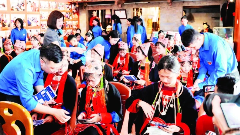 Đoàn viên thanh niên hướng dẫn người dân cài đặt ứng dụng, tiện ích số trên điện thoại thông minh.