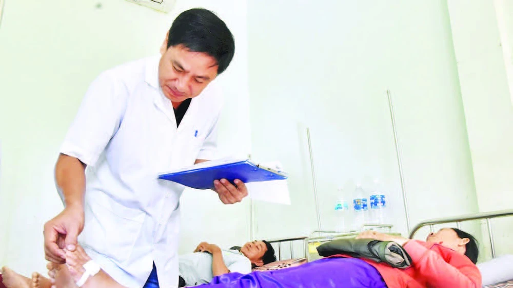 Thượng tá, bác sĩ chuyên khoa I Nguyễn Văn Tuấn, Trưởng Khoa điều trị rắn cắn khám bệnh cho bệnh nhân.