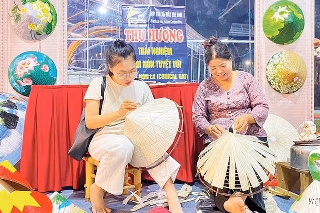Khách trải nghiệm chằm nón tại gian hàng Hợp tác xã Mây tre nón lá Thu Hương, xã Thanh Oai.