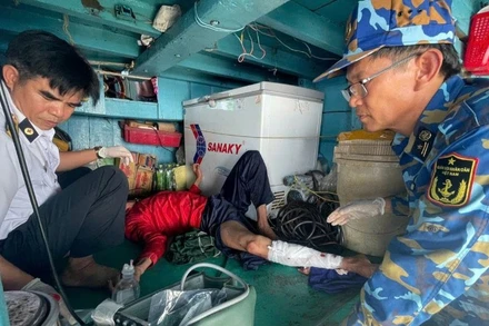 Quân y nhà giàn tiếp cận và vệ sinh, băng bó chân gãy cho nạn nhân.